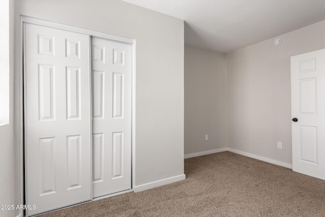 unfurnished bedroom with a closet and carpet flooring