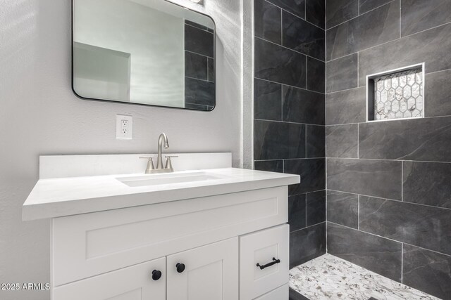 bathroom with vanity and tiled shower