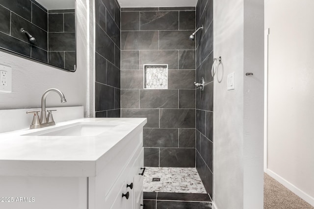 bathroom with vanity and a tile shower