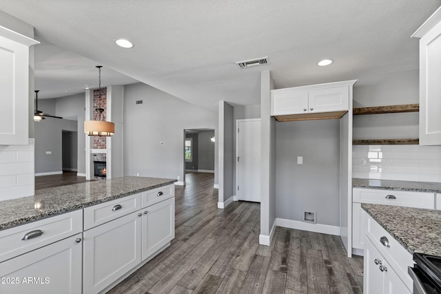 3822 E Florian Ave, Mesa, AZ 85206 - kitchen featuring decorative backsplash, white cabinetry, wood finished floors, stainless steel electric stove, and lofted ceiling