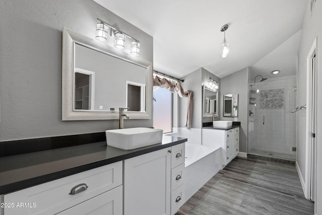 3822 E Florian Ave, Mesa, AZ 85206 - bathroom featuring a shower stall, vaulted ceiling, two vanities, wood finished floors, and a garden tub