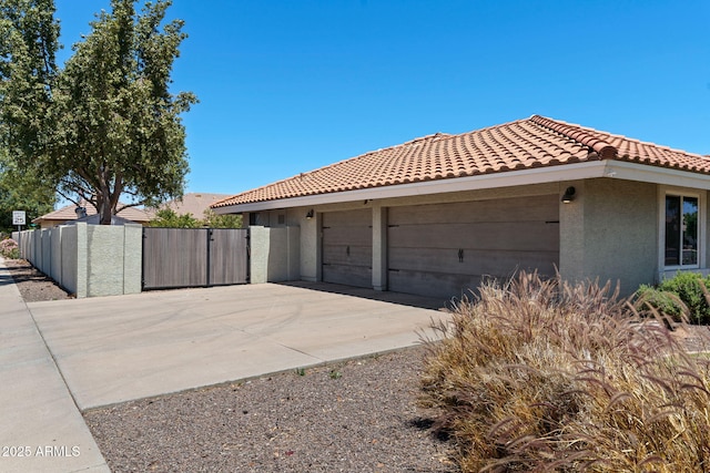3822 E Florian Ave, Mesa, AZ 85206 - view of property exterior with a gate, stucco siding, a tiled roof, concrete driveway, and fence