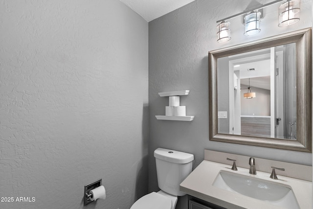 3822 E Florian Ave, Mesa, AZ 85206 - half bathroom featuring toilet, vanity, and a textured wall