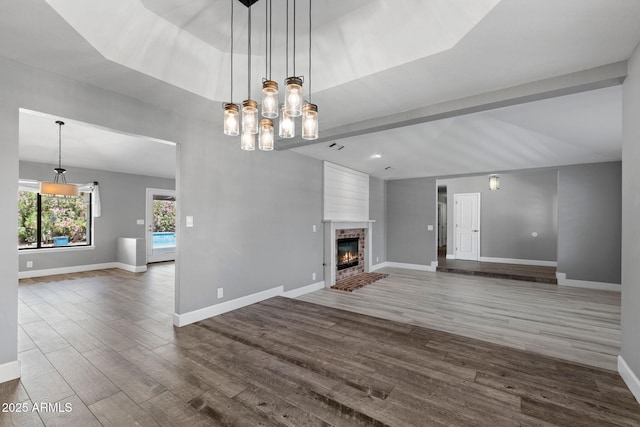 3822 E Florian Ave, Mesa, AZ 85206 - unfurnished living room with dark wood-style flooring, a brick fireplace, baseboards, and lofted ceiling