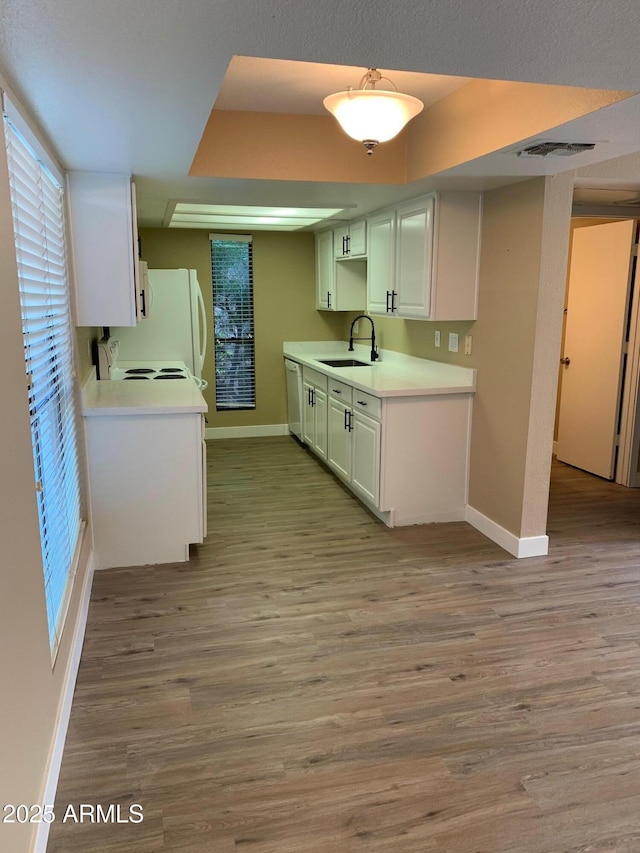 3131 W Cochise Dr Unit 218, Phoenix, AZ 85051 - kitchen featuring light countertops, a sink, white appliances, baseboards, and light wood-style flooring