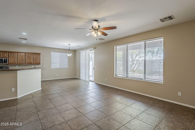 5926 W Questa Dr, Glendale, AZ 85310 - unfurnished living room with baseboards, ceiling fan, visible vents, and tile patterned floors