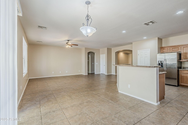 5926 W Questa Dr, Glendale, AZ 85310 - kitchen featuring stainless steel fridge, arched walkways, ceiling fan, and visible vents