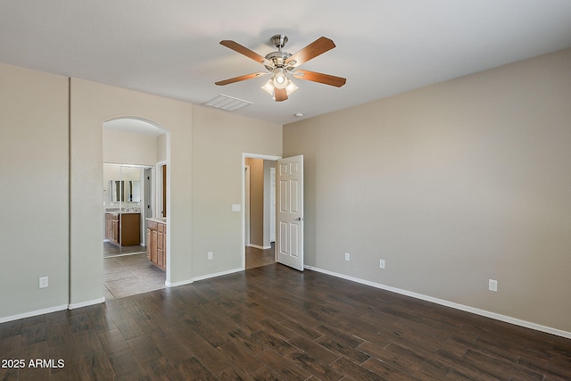5926 W Questa Dr, Glendale, AZ 85310 - unfurnished bedroom with arched walkways, baseboards, dark wood-style floors, and visible vents