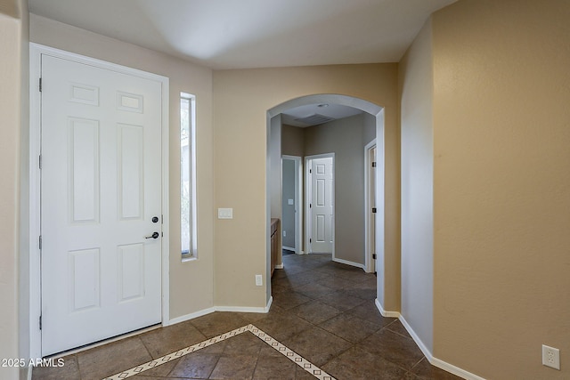 5926 W Questa Dr, Glendale, AZ 85310 - foyer with dark tile patterned floors, arched walkways, and baseboards