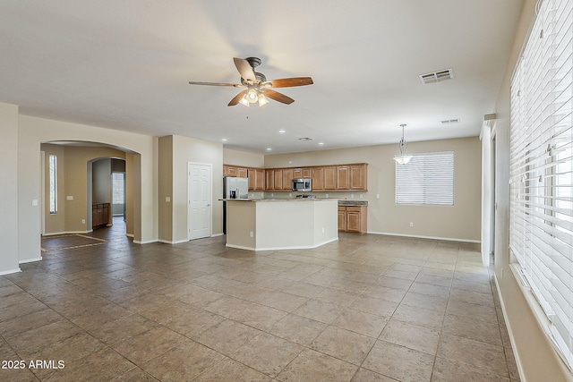 5926 W Questa Dr, Glendale, AZ 85310 - unfurnished living room featuring visible vents, a ceiling fan, baseboards, recessed lighting, and arched walkways
