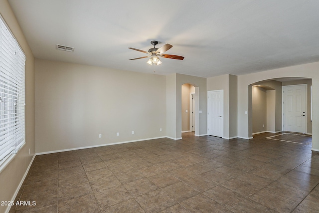 5926 W Questa Dr, Glendale, AZ 85310 - spare room featuring arched walkways, ceiling fan, baseboards, and visible vents