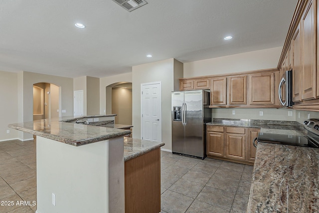 5926 W Questa Dr, Glendale, AZ 85310 - kitchen featuring visible vents, appliances with stainless steel finishes, arched walkways, baseboards, and recessed lighting