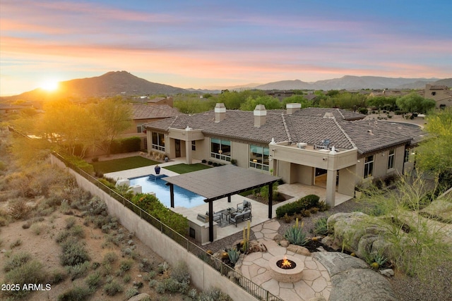 8599 E Sand Flower Dr, Scottsdale, AZ 85266 - pool at dusk with a patio, a fenced backyard, an outdoor fire pit, and a mountain view