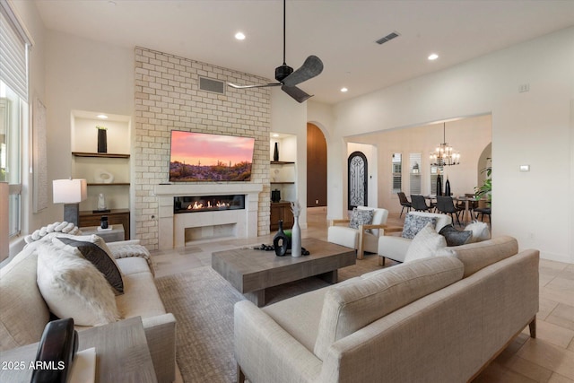 8599 E Sand Flower Dr, Scottsdale, AZ 85266 - living room featuring built in shelves, arched walkways, a fireplace, visible vents, and recessed lighting
