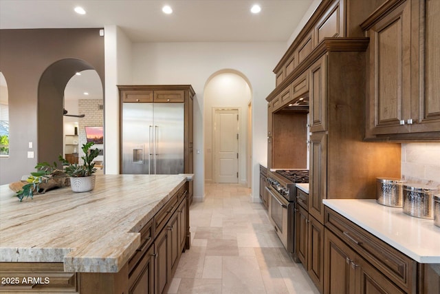 8599 E Sand Flower Dr, Scottsdale, AZ 85266 - kitchen featuring a center island, arched walkways, recessed lighting, backsplash, and high end appliances
