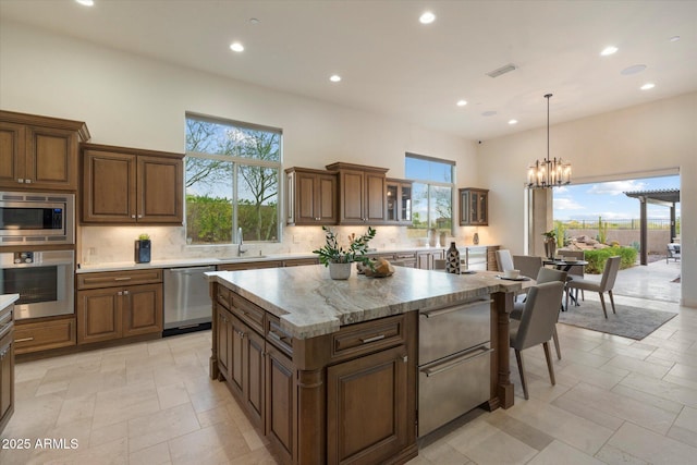 8599 E Sand Flower Dr, Scottsdale, AZ 85266 - kitchen featuring visible vents, decorative backsplash, stainless steel appliances, and a sink