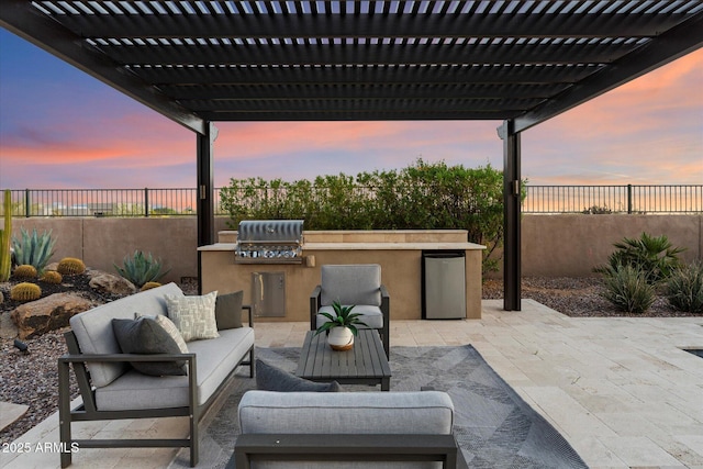 8599 E Sand Flower Dr, Scottsdale, AZ 85266 - patio terrace at dusk featuring an outdoor kitchen, a pergola, a fenced backyard, and an outdoor living space