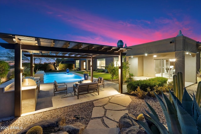 8599 E Sand Flower Dr, Scottsdale, AZ 85266 - patio terrace at dusk featuring a pergola, an outdoor pool, and exterior kitchen
