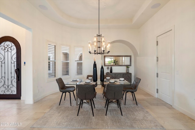 8599 E Sand Flower Dr, Scottsdale, AZ 85266 - dining space with baseboards, arched walkways, a notable chandelier, and a tray ceiling