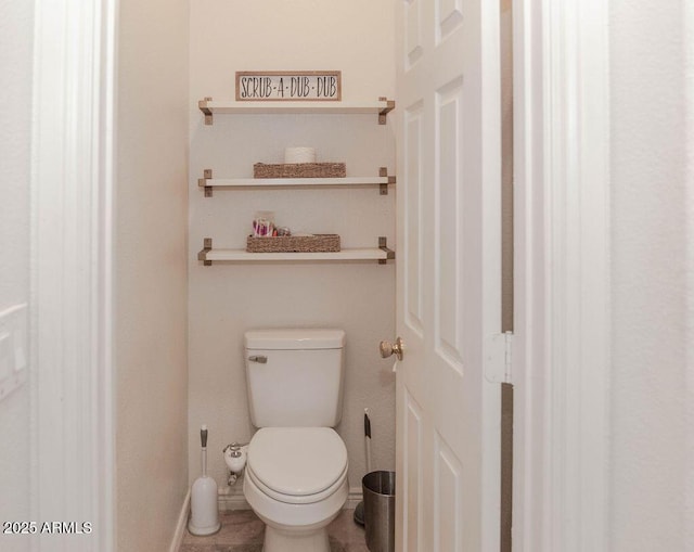bathroom with baseboards and toilet