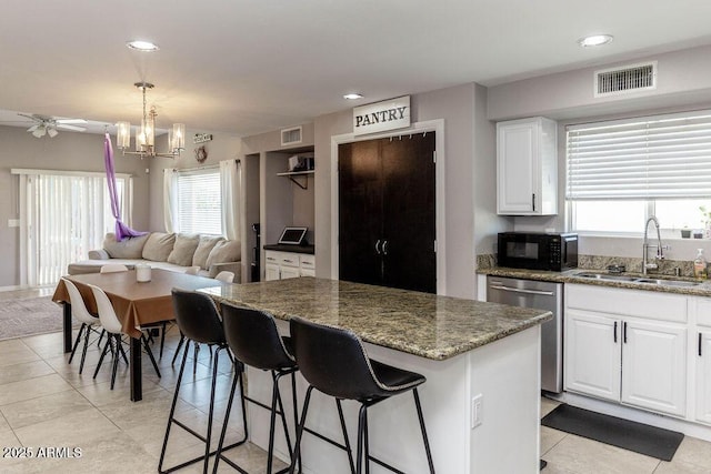 kitchen featuring visible vents, a sink, black microwave, and stainless steel dishwasher