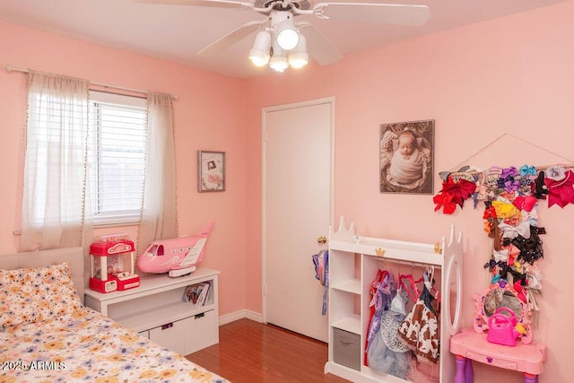 bedroom with baseboards, ceiling fan, and wood finished floors