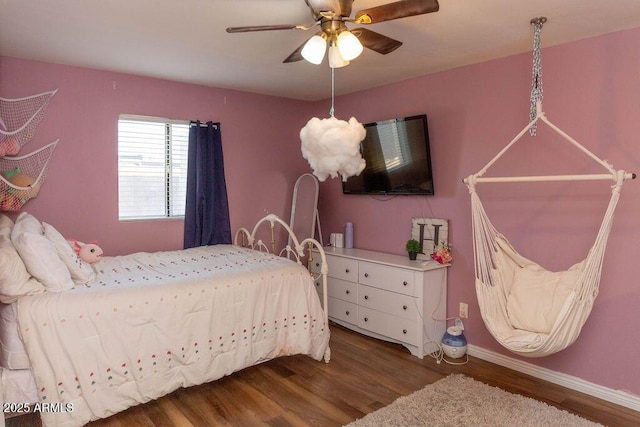 bedroom with a ceiling fan, baseboards, and wood finished floors