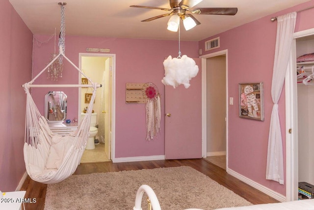 interior space with baseboards, visible vents, wood finished floors, and ceiling fan with notable chandelier