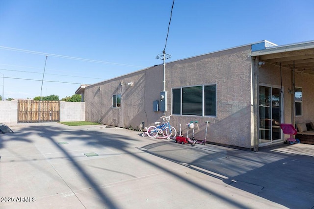 back of property featuring fence and a patio