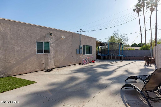 view of patio with a fenced backyard and a trampoline