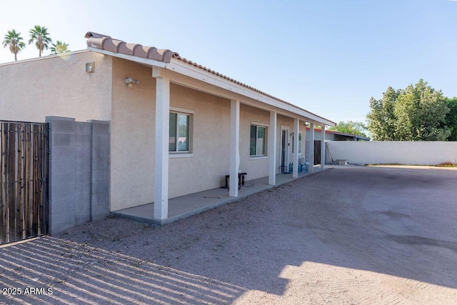 view of side of home with fence and stucco siding