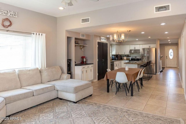 living room featuring visible vents, recessed lighting, and ceiling fan with notable chandelier
