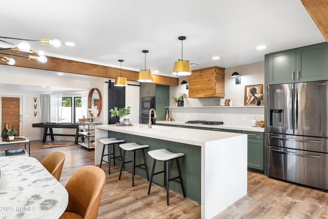 kitchen with a kitchen breakfast bar, decorative light fixtures, stainless steel appliances, light wood-style floors, and green cabinetry