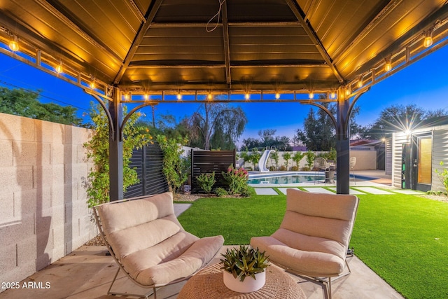 patio terrace at dusk with a fenced in pool, an outdoor structure, a gazebo, and a shed