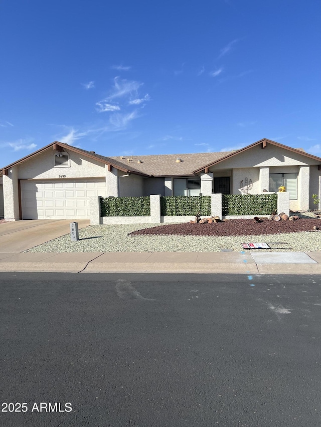 view of front of house with a garage, driveway, and stucco siding