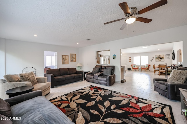 living room featuring arched walkways, ceiling fan, a textured ceiling, and recessed lighting