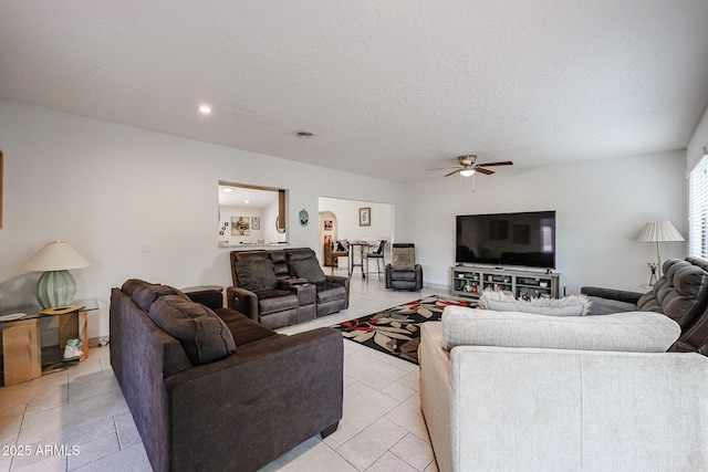 living room with light tile patterned floors, visible vents, a ceiling fan, a textured ceiling, and recessed lighting