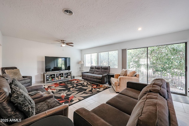 living room with ceiling fan, visible vents, a textured ceiling, and recessed lighting