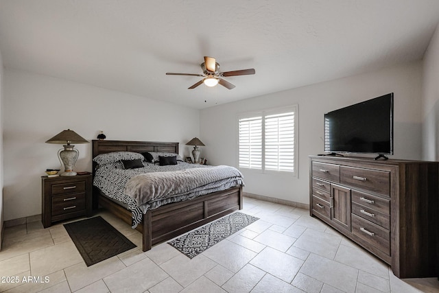 bedroom featuring light tile patterned flooring, a ceiling fan, and baseboards