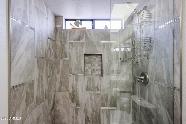 full bath featuring a marble finish shower and a textured ceiling