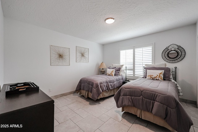 bedroom featuring baseboards and a textured ceiling