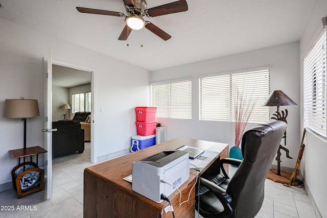 office area with light tile patterned floors, ceiling fan, and baseboards