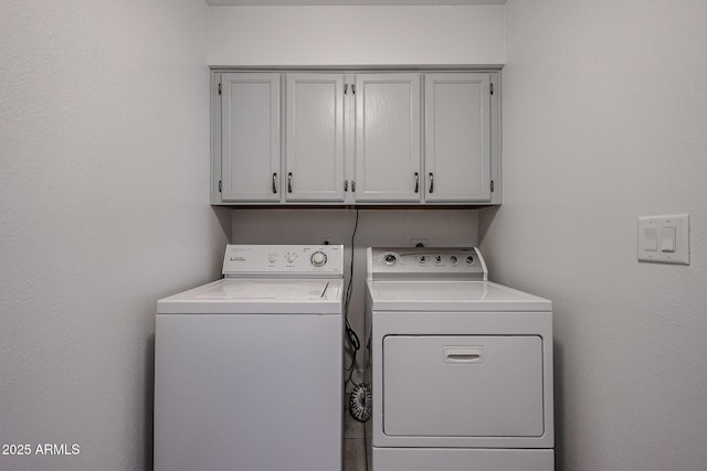 laundry area with separate washer and dryer and cabinet space