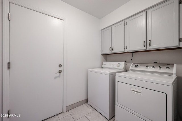 laundry room with cabinet space, washing machine and dryer, light tile patterned floors, and baseboards