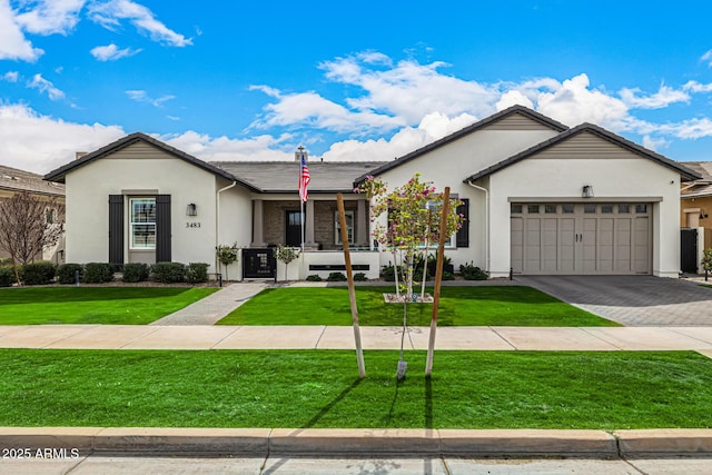 single story home featuring decorative driveway, a front lawn, an attached garage, and stucco siding