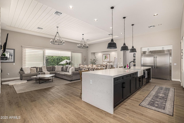 kitchen featuring light countertops, light wood-style flooring, visible vents, and built in refrigerator