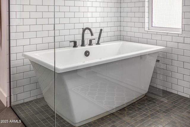 bathroom featuring tile patterned flooring, tile walls, and a soaking tub