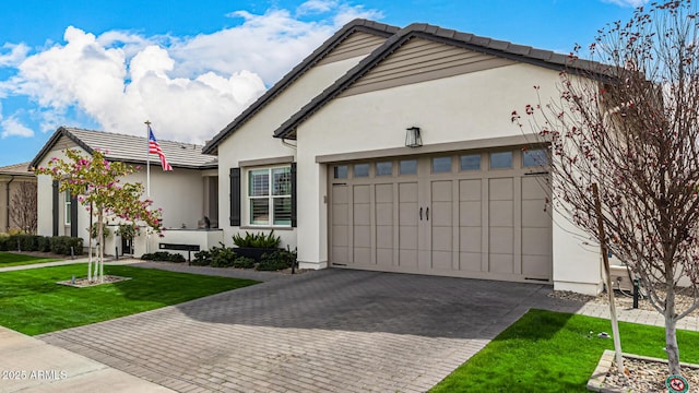 view of front facade with a front yard, decorative driveway, an attached garage, and stucco siding