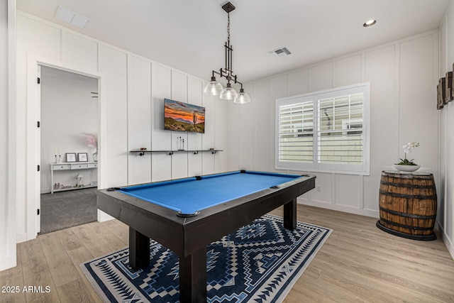 rec room with billiards, a decorative wall, light wood-style floors, and visible vents