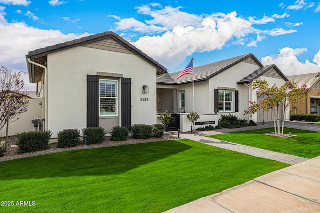 ranch-style home with stucco siding, a front yard, an attached garage, and driveway